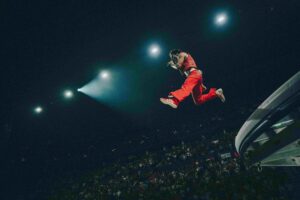 A man dressed in red leaping mid-air.