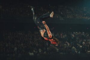 A man dressed in black flying through the air upside down.