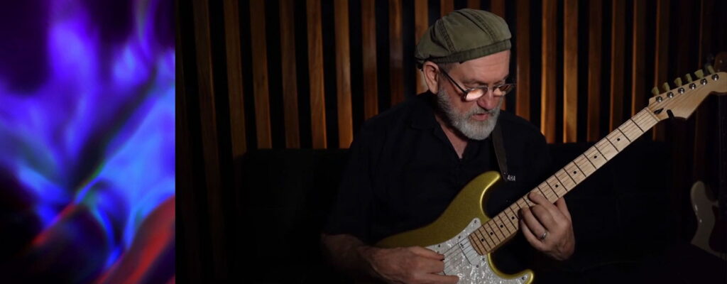 Erick Hailstone strumming the guitar