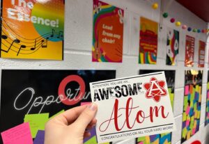 hand holding card saying "Awesome Atom" for student recognition