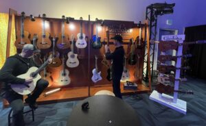 A display of Cordoba acoustic guitars and ukeleles at a trade show.