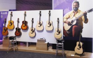 A display of Yamaha acoustic guitars at a trade show.