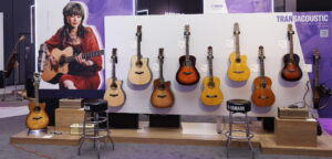 A display of Yamaha TransAcoustic guitars at a trade show.