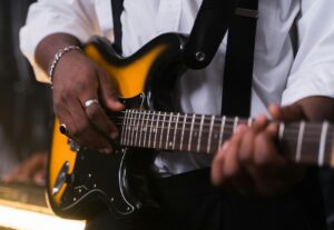 close up of someone playing the electric guitar