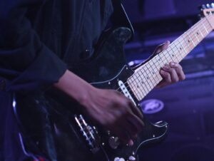 close up of someone playing the electric guitar