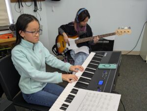 students playing electric guitar and keyboards