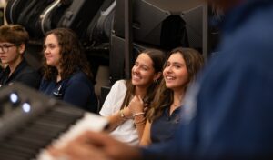 happy group of band students sitting on floor 