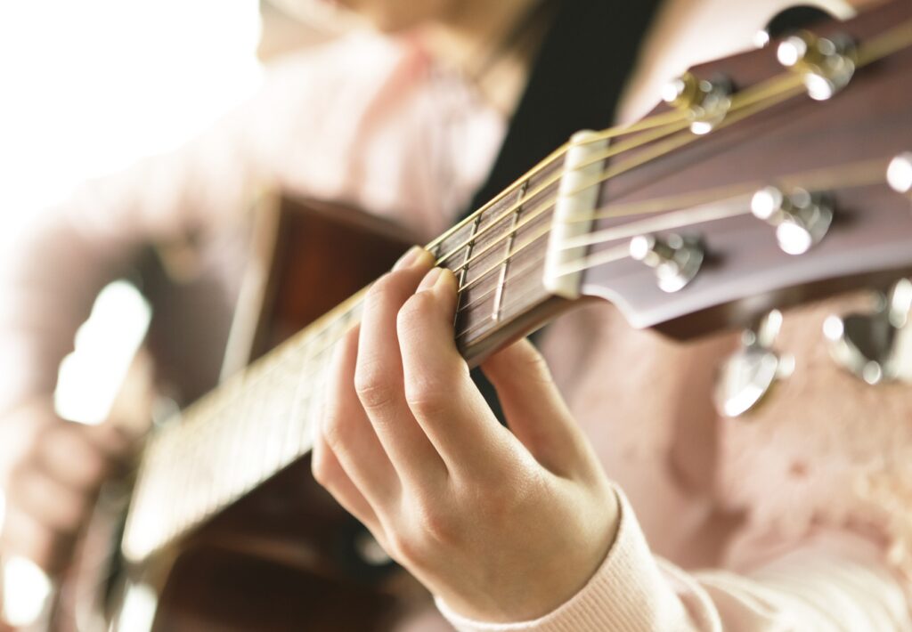 closeup of someone playing an acoustic guitar