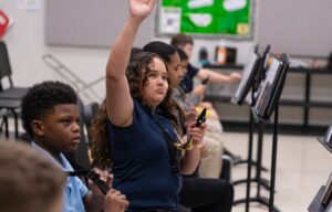 band rehearsal with one student raising her hand