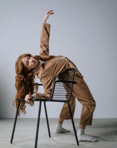 flexible woman bending over backward over a chair