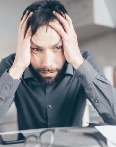 frustrated man with hands on both sides of his head