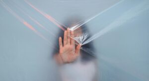 hand held up to plastic sheet