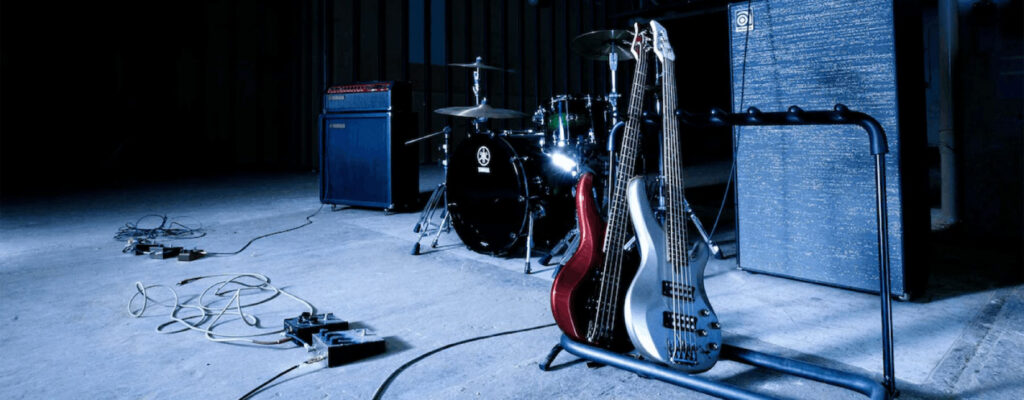 Picture of a stage with row of bass guitars in stands sitting on stage