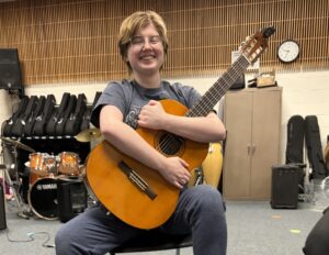 student hugging guitar