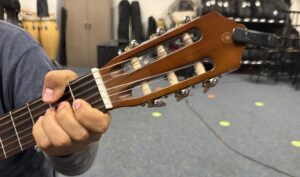hand gripping neck of guitar