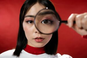 female looking through magnifying glass
