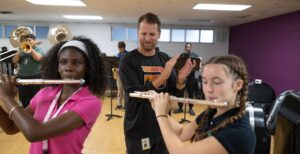 music teacher overseeing rehearsal of flute players