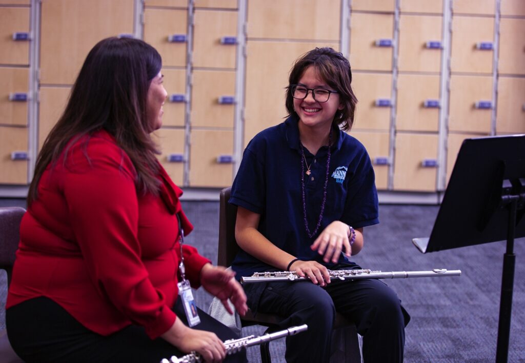 music teacher working one-on-one with flute student