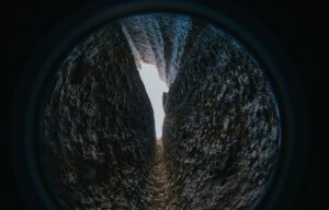 looking through lens of a narrowing passageway through a cave 