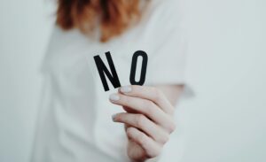 someone holding up letters that spell "no"