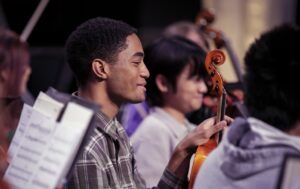 orchestra rehearsal with student holding violin