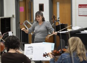 teacher conducting parent orchestra rehearsal 