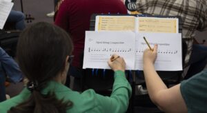 two parents making notes on sheet music
