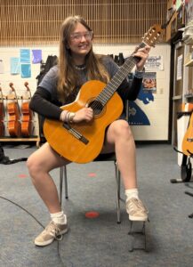 student holding guitar