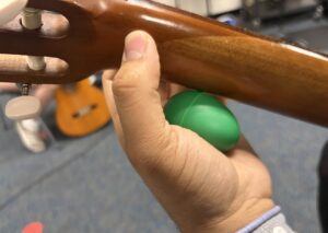 guitar student holding guitar and egg shaker in left hand