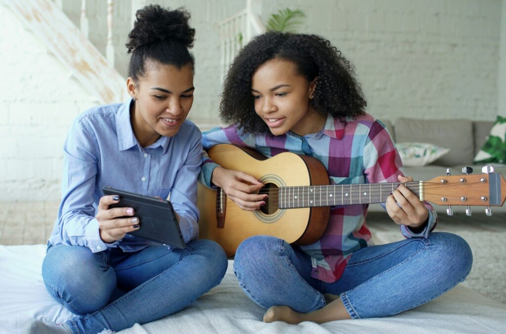 two teens with guitar and tablet