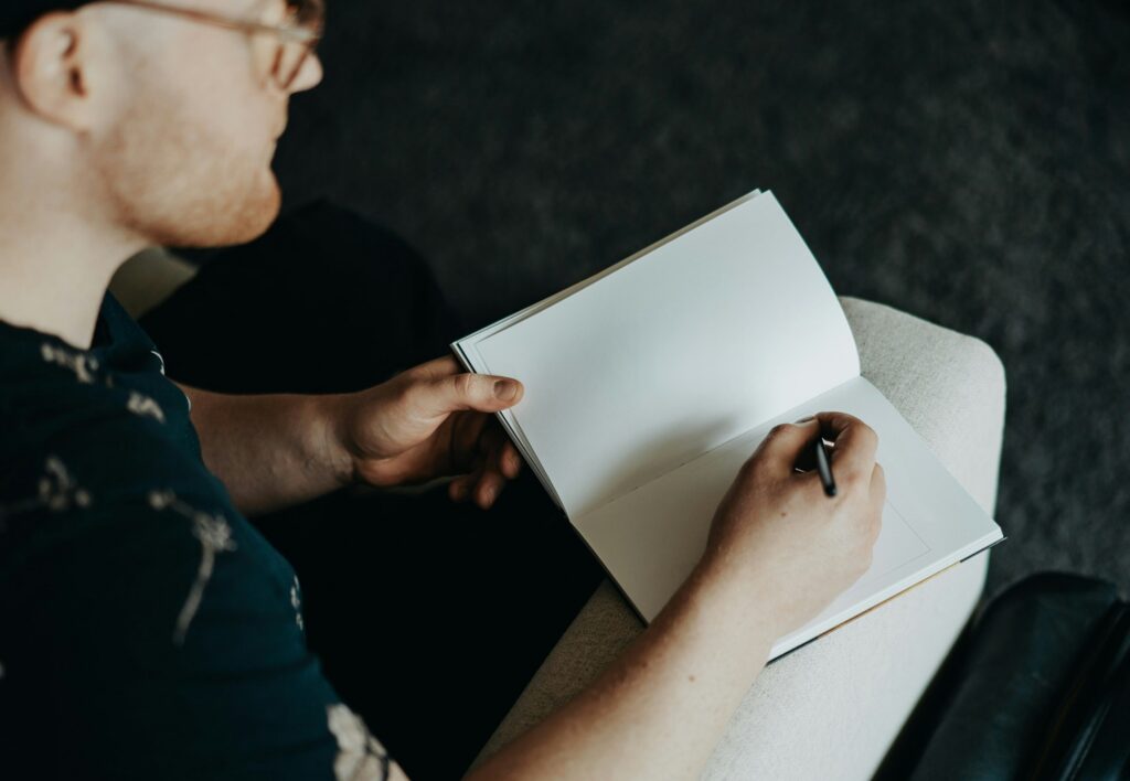 man writing in journal