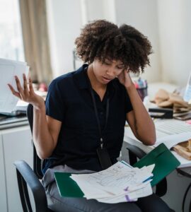 exasperated woman with a folder of disorganized papers