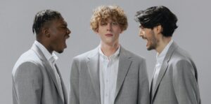 man standing between two angry men yelling at each other 