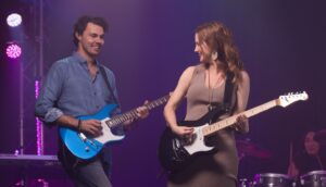 two students playing guitars