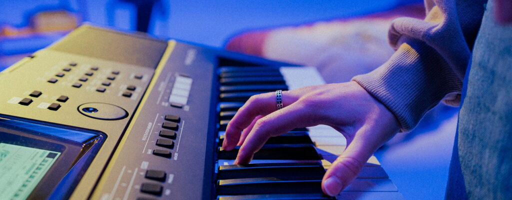 Hands playing on an electric keyboard