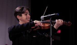 student standing at mic playing violin