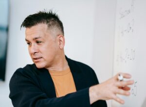 man at white board explaining concept