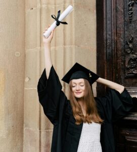 graduate holding diploma high in the air