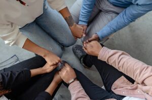 four people clasping hands
