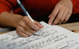 close up of hand writing on music score