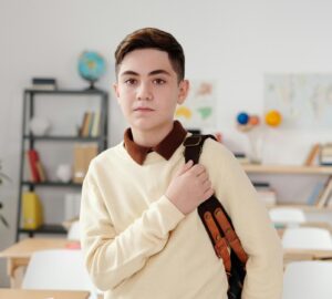 serious looking student standing and wearing a backpack