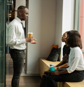 standing man meeting with two women sitting