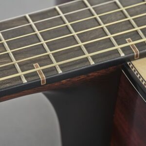 Closeup of the joint between an acoustic guitar neck and body.