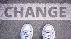 someone standing at the word "change" painted on the ground