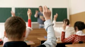 class with students holding up their hands