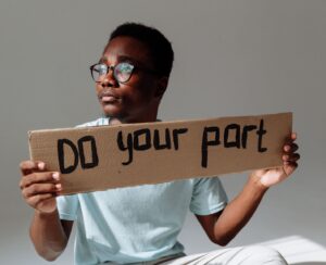 man holding sign that says "Do your part"