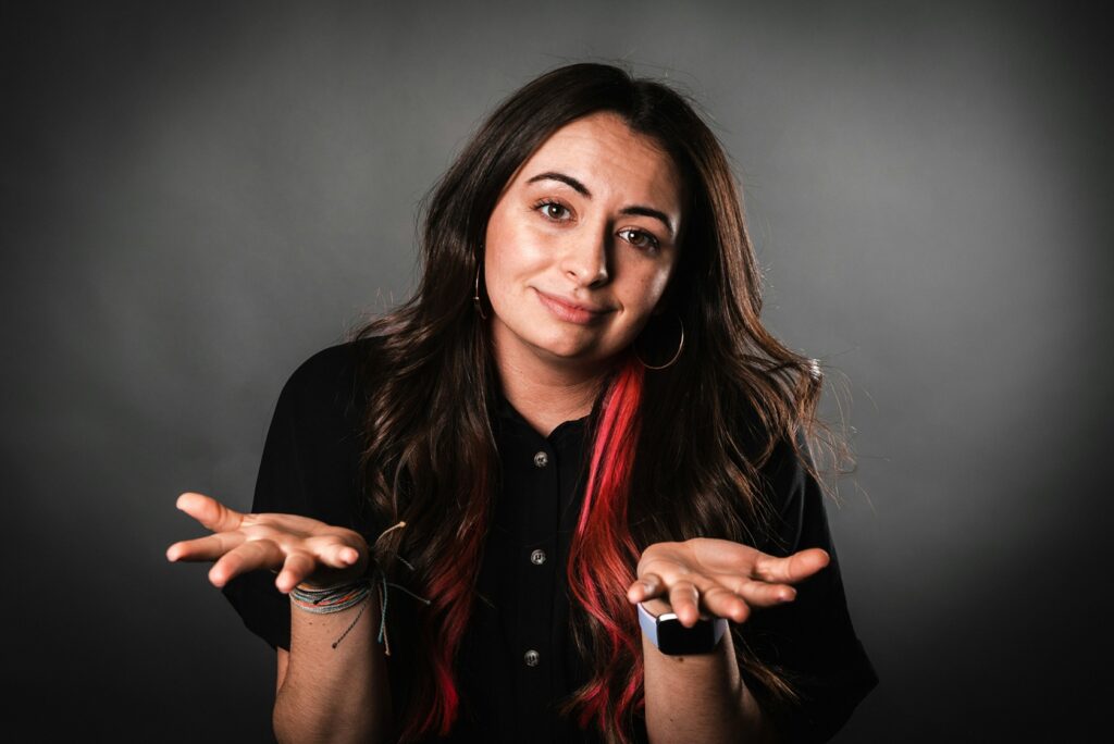 woman shrugging and holding hands in front of her indicating she doesn't know