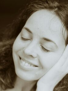 female smiling with eyes closed and looking relaxed