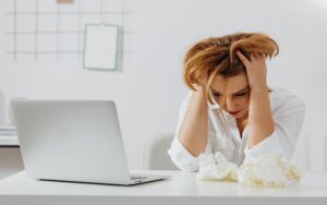 overwhelmed woman holding her head in her hands 