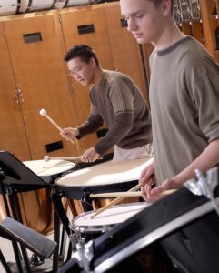 two percussion students playing the timpani and snare drum